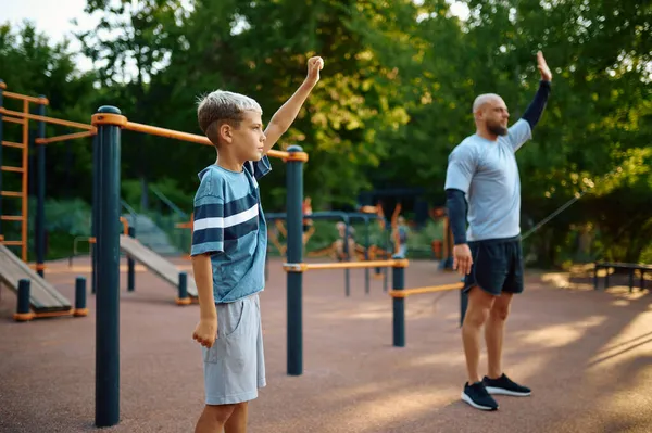 Папа и сын, спортивные тренировки на детской площадке — стоковое фото