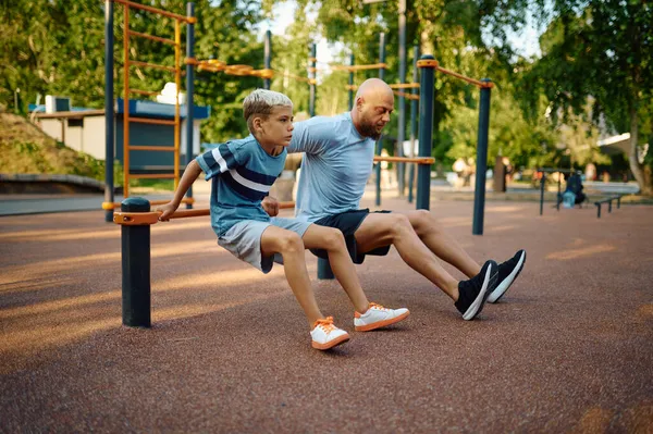 Πατέρας και αγόρι κάνουν γυμναστική, αθλητική εκπαίδευση. — Φωτογραφία Αρχείου