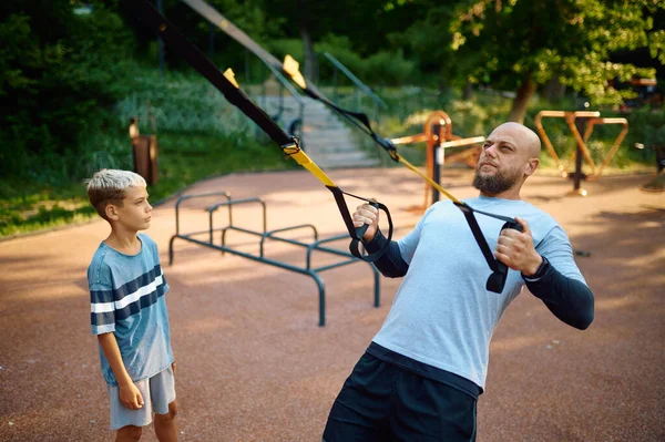 Отец и мальчик, упражнения с веревками на детской площадке — стоковое фото