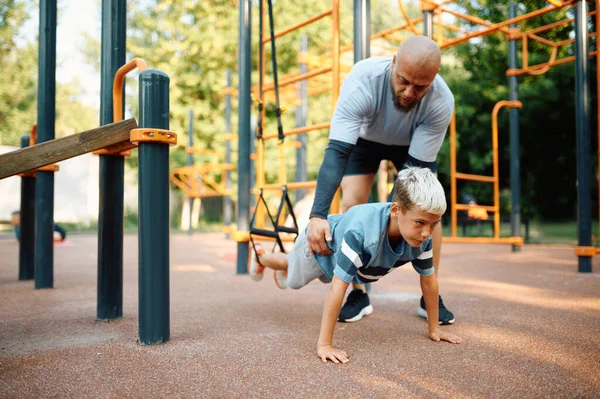 Papa en jongen doen oefeningen met touwen buiten — Stockfoto