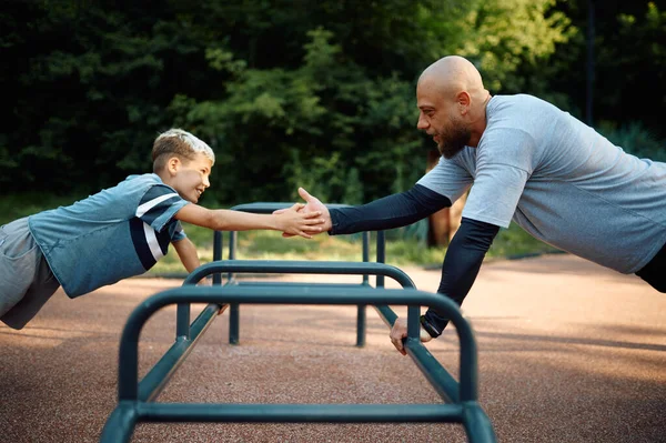 Pai e menino, exercício push-up no parque infantil — Fotografia de Stock