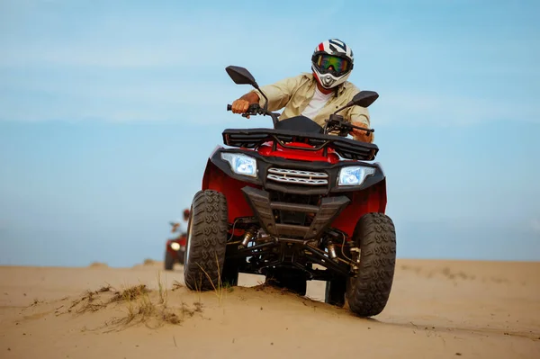 Man in helmet rides on atv in desert, action view — Stock Photo, Image
