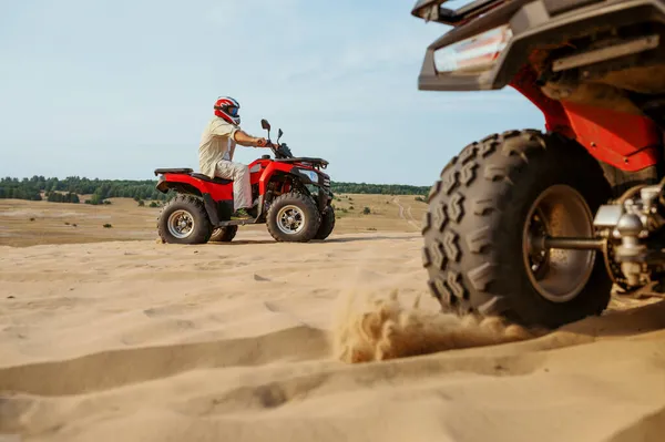 View on atv wheel, man in helmet on background — Stock Photo, Image