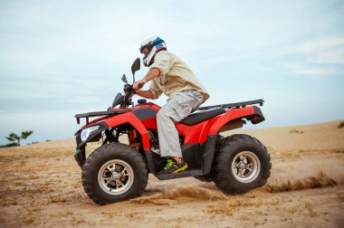 Çölde yarışan bir ATV sürücüsü