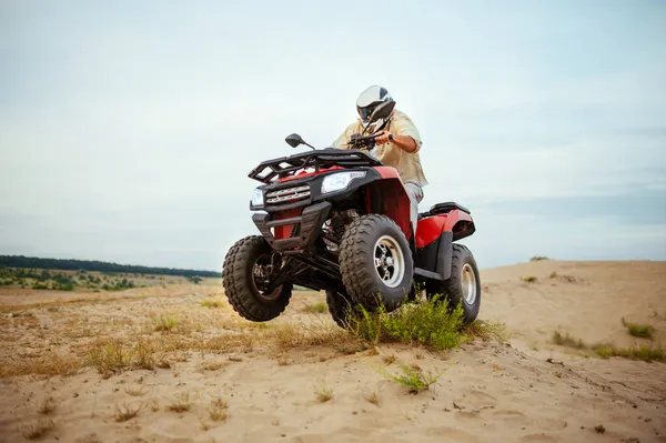 Atv versenyző sisak lovaglás sivatagban, akció nézet — Stock Fotó