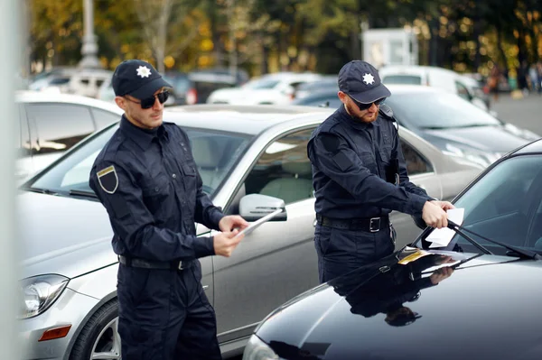 警察官は駐車場でチケットを発行します — ストック写真
