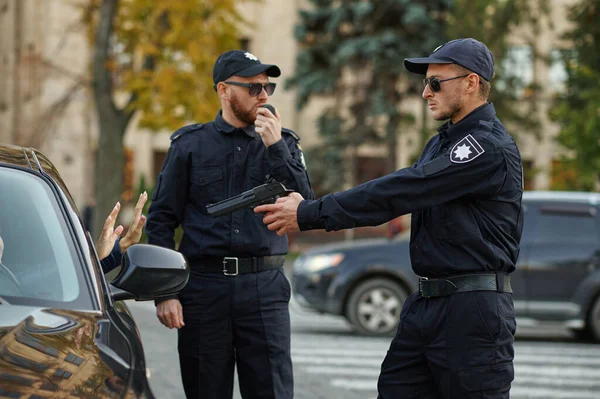 Polizeibeamte mit Waffe nehmen Autofahrerin fest — Stockfoto