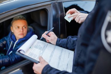 Polis devriyesi sürücü ehliyetini kontrol ediyor.