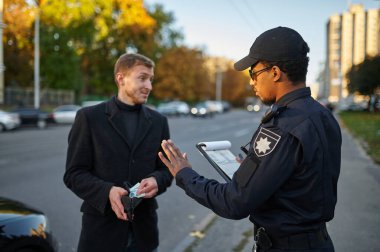 Polis memuru şoförden rüşvet almayı reddediyor.