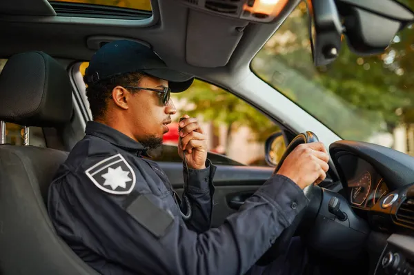 Mannelijke politieagent aan het praten op een walkie-talkie — Stockfoto
