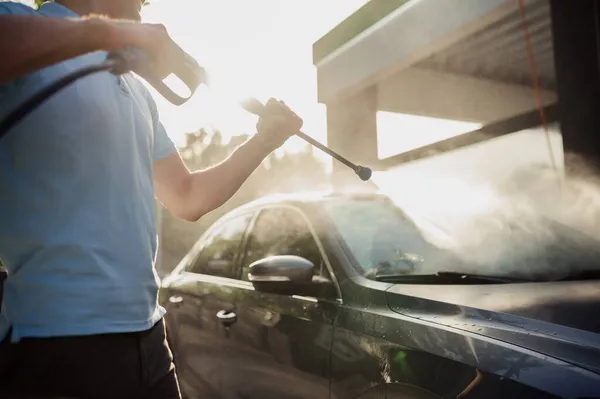 El hombre tiene pistola de agua de alta presión, lavado de autos a mano — Foto de Stock