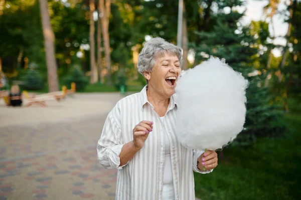 Oma isst Zuckerwatte, zurück in die Kindheit — Stockfoto