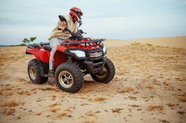 Çölde yarışan bir ATV sürücüsü