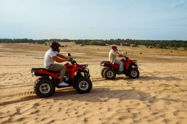 ATV tekerleğinde görünüm, arka planda miğferli adam