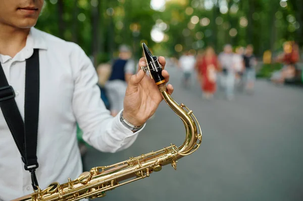 Jonge saxofonist met saxofoon in steegje in park — Stockfoto