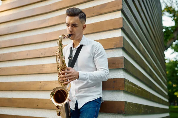 Saxofonista masculino toca melodia na rua — Fotografia de Stock