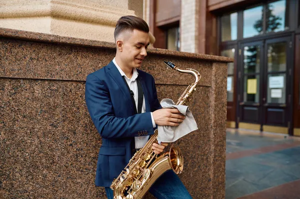 Mężczyzna saksofonista pozuje z saksofonem w budynku — Zdjęcie stockowe