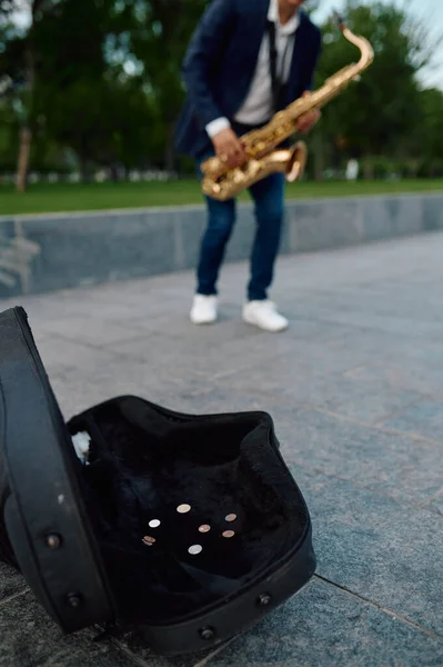 Мужчина-саксофонист играет мелодию в парке, талант — стоковое фото
