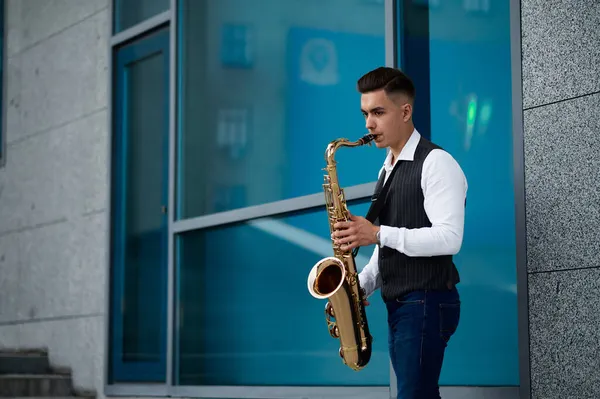 Saxofonista hraje melodii na schodech na ulici — Stock fotografie