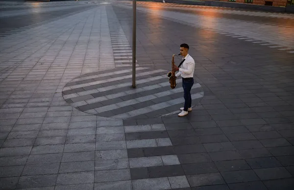 Saxofonista hraje večer na saxofon na ulici — Stock fotografie
