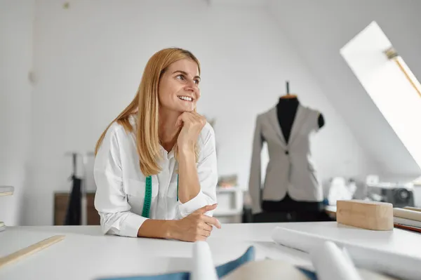 Happy dressmaker pózuje na pracovišti v dílně — Stock fotografie