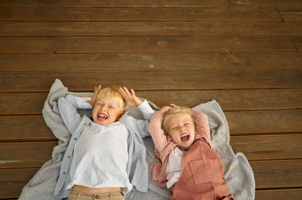 Funny children lying on terrace floor in trailer — Stock Photo, Image