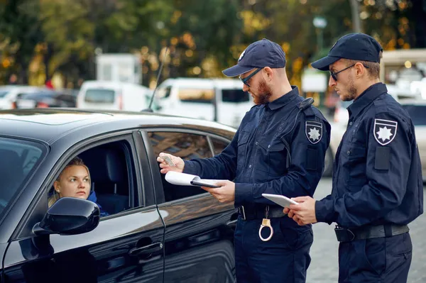 Mannelijke politieagenten controleren het rijbewijs — Stockfoto