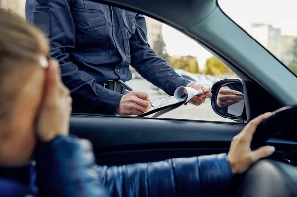 Politieagent schrijft een protocol uit aan de bestuurder — Stockfoto