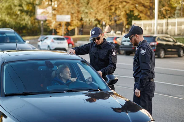 Поліцейський патруль перевіряє водія жінки — стокове фото