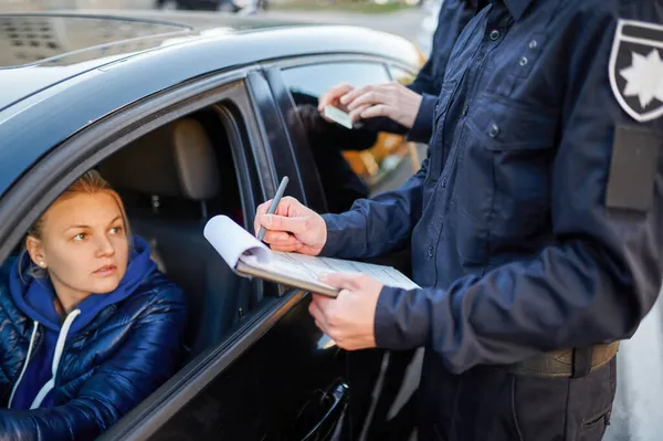 Patrulla policial verificando licencia de conducir del conductor — Foto de Stock