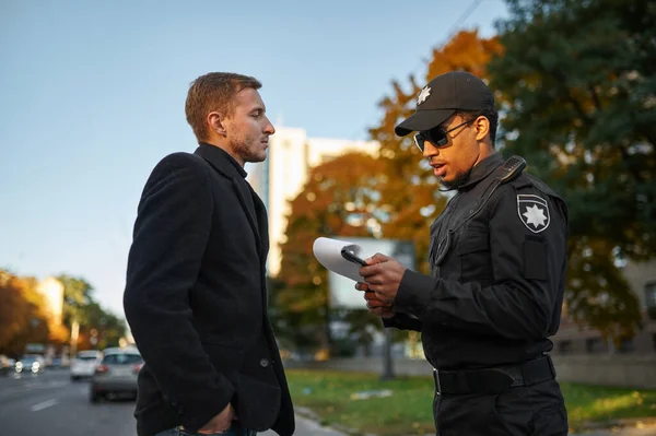 Männlicher Polizeibeamter stellt Bußgeld für Fahrer aus — Stockfoto