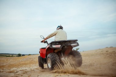 Çölde yarışan bir ATV sürücüsü
