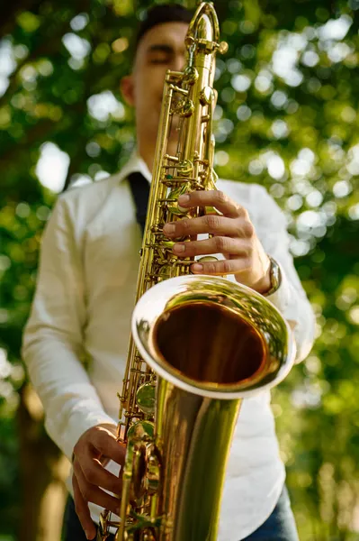 Jovem saxofonista toca melodia no saxofone dourado — Fotografia de Stock