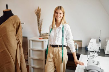 Neşeli terzi işyerinde poz veriyor.