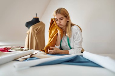 Yorgun terzi atölyede düşünüyor.