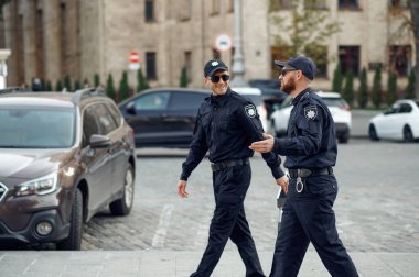 Güneş gözlüklü iki gülümseyen erkek polis memuru.