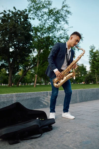 Masculino saxofonista toca melodia no parque, talento — Fotografia de Stock