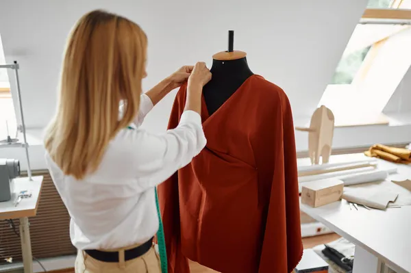 Costurera intenta en el vestido en el maniquí en el taller — Foto de Stock