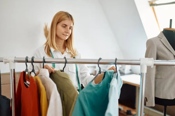 Seamstress choosing dress in atelier, dressmaker — Stock Photo, Image