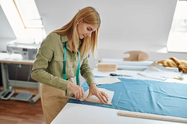 Costurera con tijeras corta tela en taller — Foto de Stock