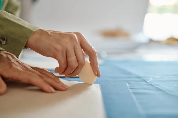 Dressmaker measures cloth on the table in workshop — Stock Photo, Image