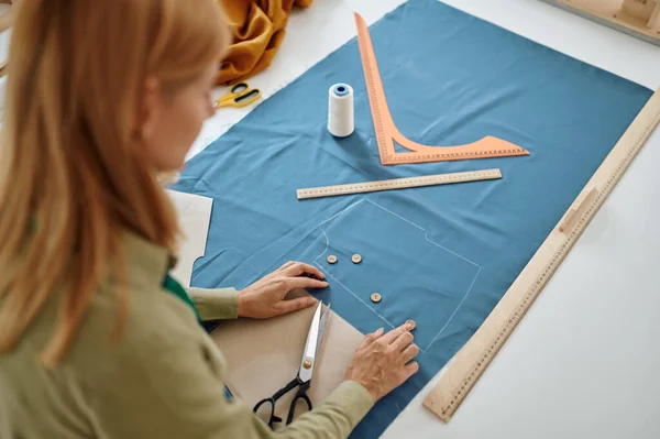 Dressmaker misura stoffa sul tavolo in officina — Foto Stock