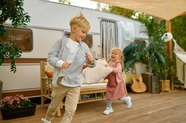 Funny kids play at the trailer, summer camping — Stock Photo, Image