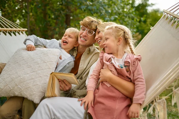 Fröhliche Familie, die Spaß auf der Hängematte hat, campt — Stockfoto