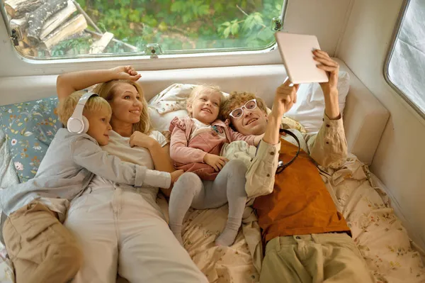 Stock image Cheerful family lying in bed in motorhome, camping