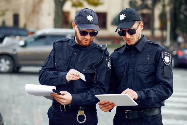 Deux policiers masculins inspectent le parking — Photo