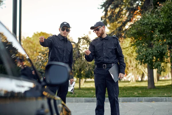 Politieagenten controleren voertuig op auto parkeren — Stockfoto