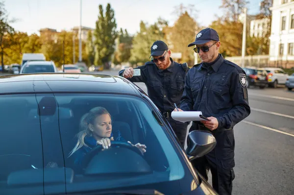 Polizeistreife kontrolliert Führerschein des Fahrers — Stockfoto