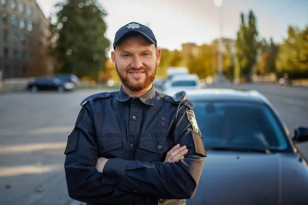 Policial masculino em uniforme posa perto do carro — Fotografia de Stock