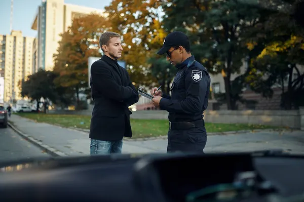 Une patrouille policière impose une amende au conducteur masculin — Photo